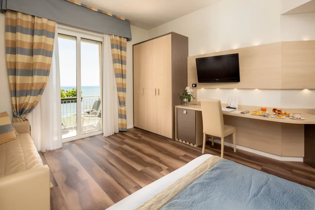 Immagine di una camera deluxe con vista mare. Si intravede la terrazza affacciata sul mare.